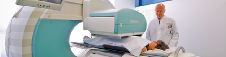 Prof. Dr. Torsten Kuwert am SPECT/CT mit einer Patientin.